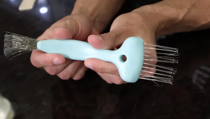 Remove hair from brush using a teasing brush.