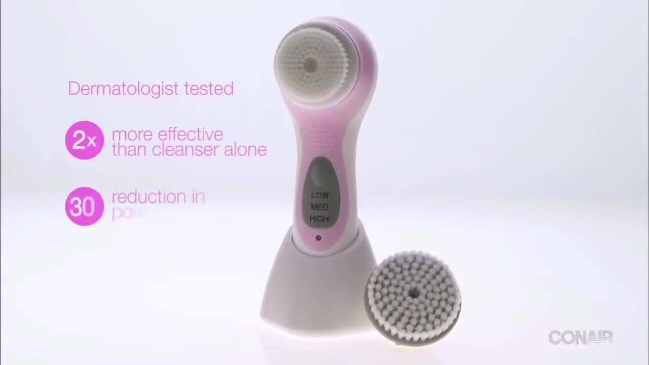 Close-up shot of the True Glow Sonic Cleansing Brush, charging stand, and two brush heads.