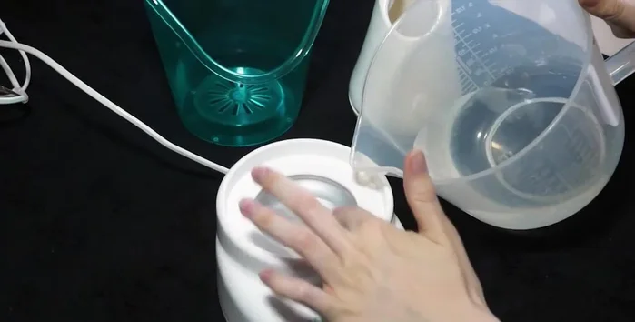 Pour water into the machine's reservoir, ensuring it's within the indicated lines.