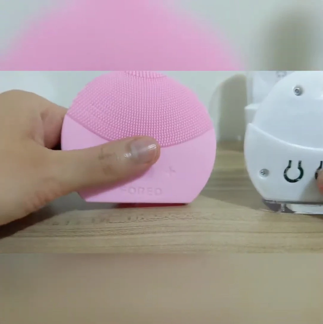 The reviewer removing the brush head from the counterfeit Luna Mini 2.