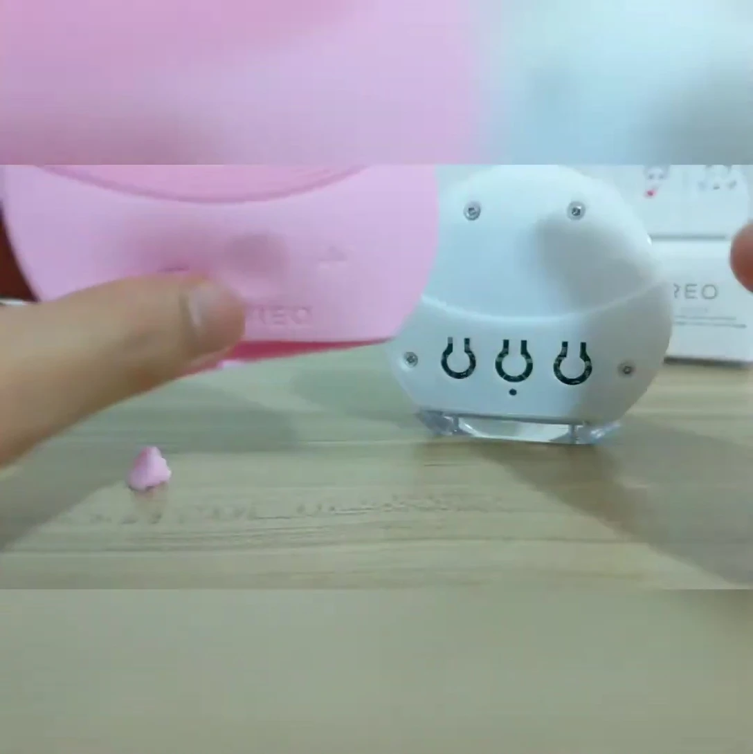 The reviewer pinching the silicone brush head to test its composition.
