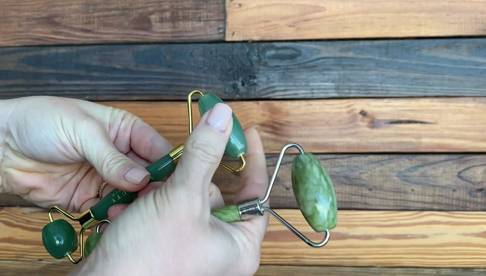 The presenter points out the origin of the jade stone used in each roller.