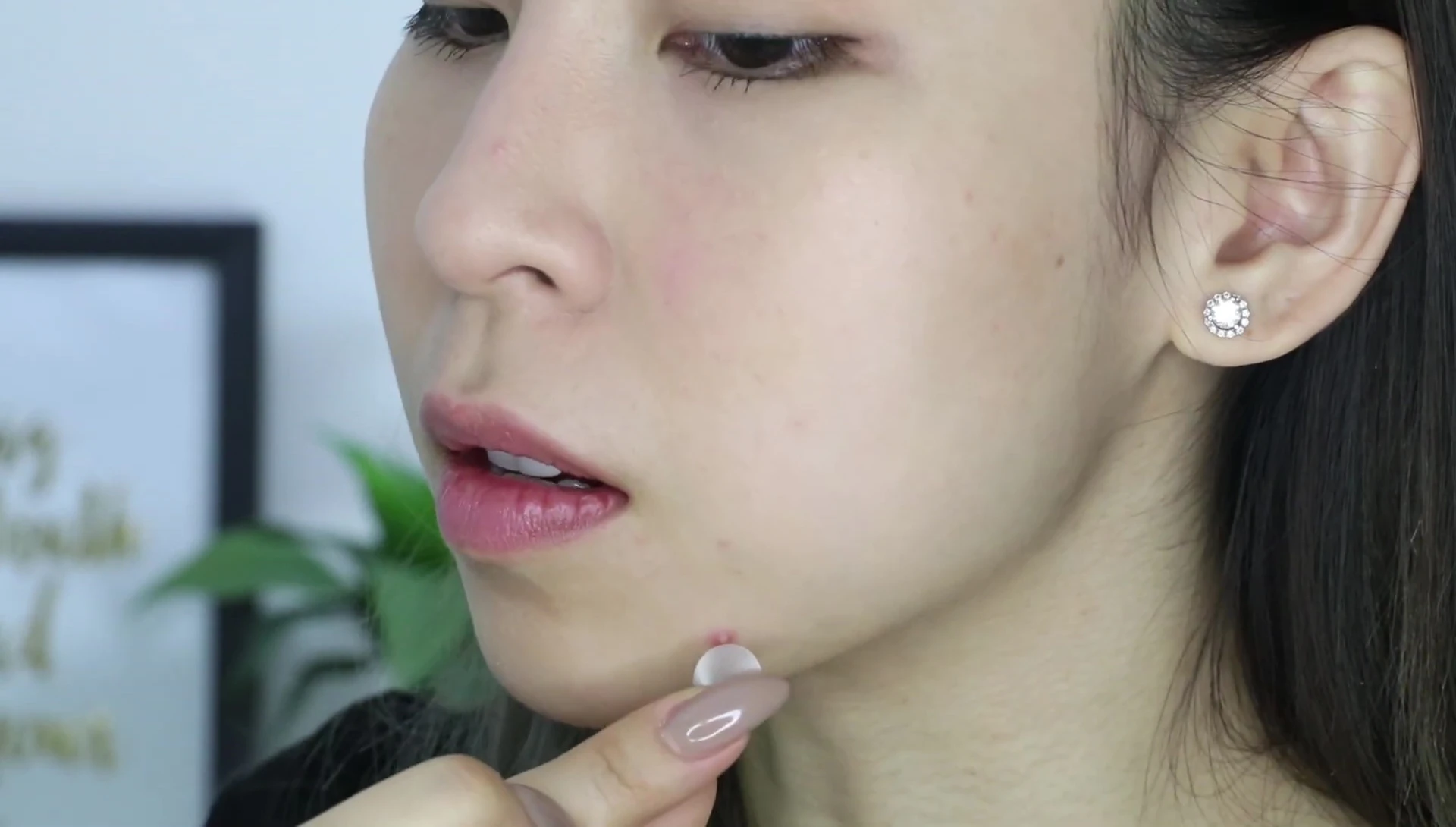 The blogger applying a blemish dot onto her pimple.