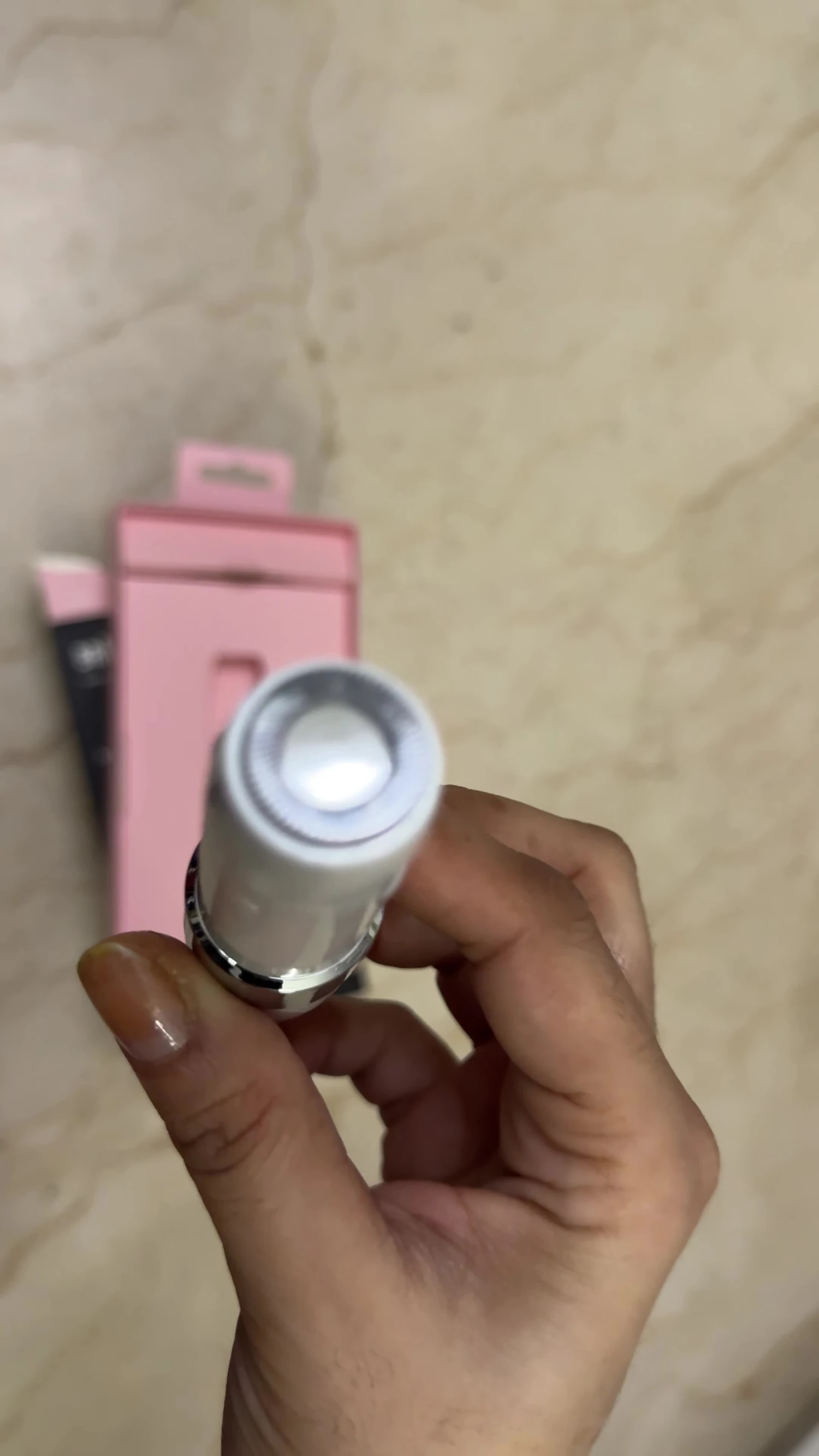 Close-up on the device, showing the buttons and hair removal mechanism.
