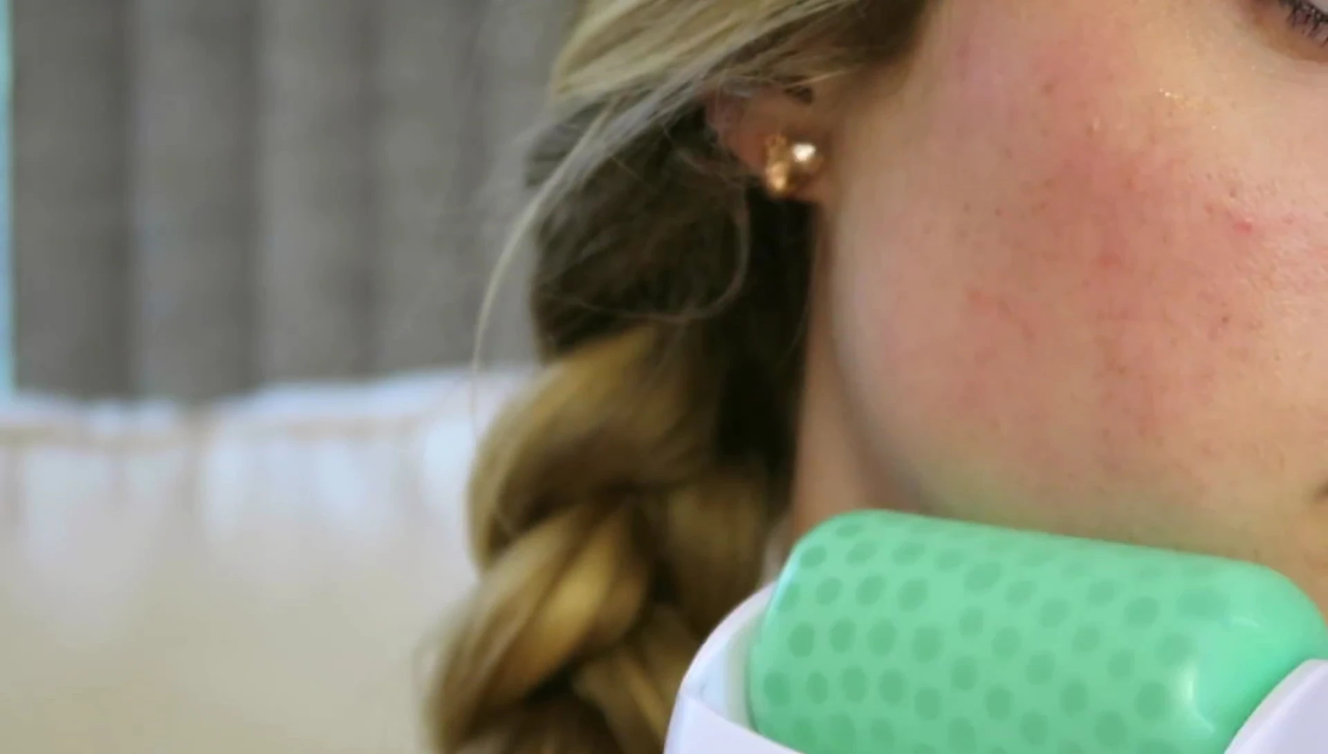 The YouTuber concentrating the ice roller on her cheeks