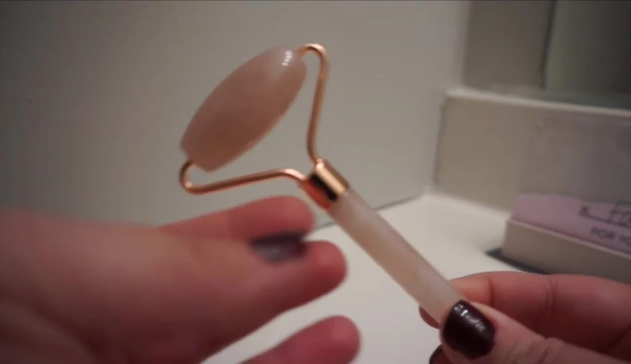 Close-up of the rose quartz face roller, highlighting its material.